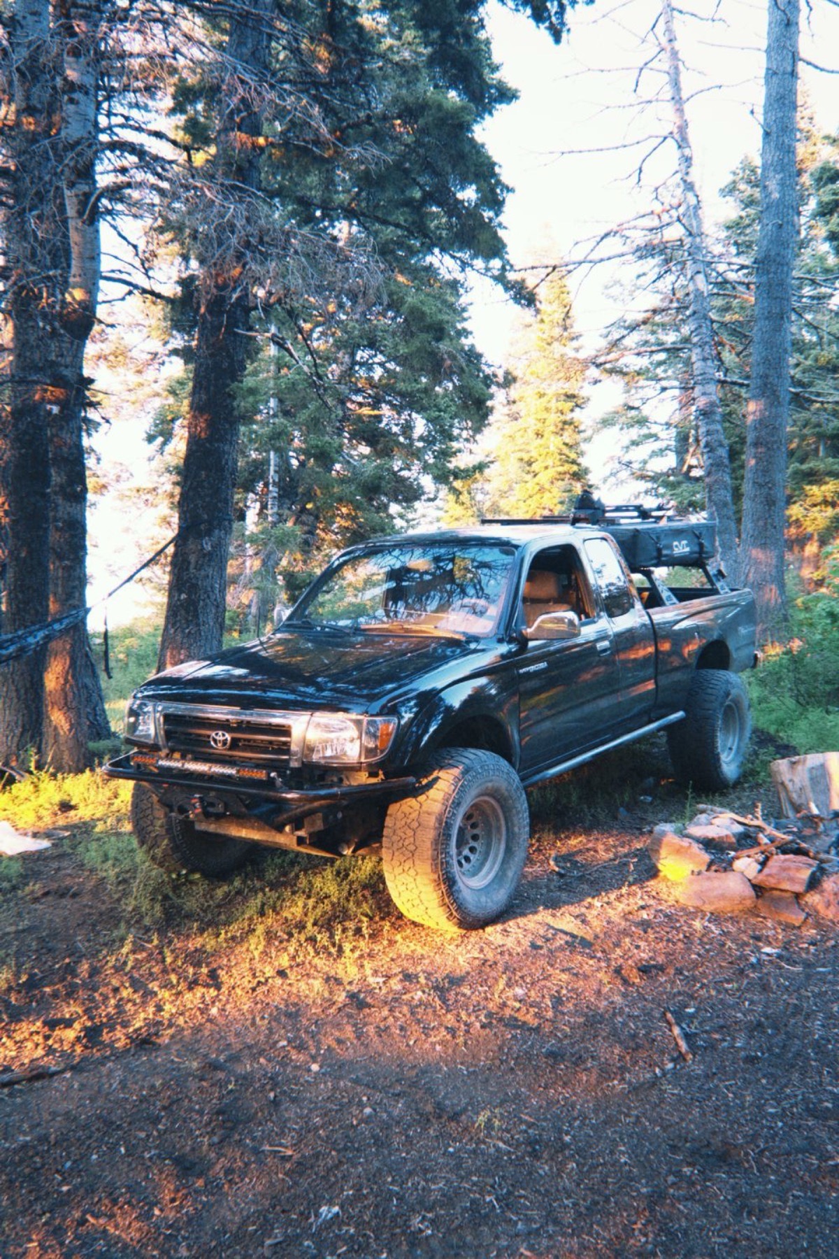 Finn's '99 Tacoma at camp in golden forest light